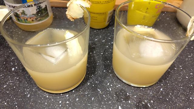 Två gulbruna drinkar med is.