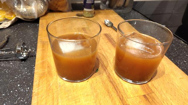 Två brunorange drinkar på en skärbräda.