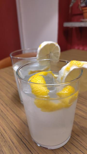 Två höga glas med vit vätska, is och citron