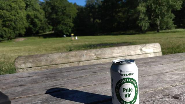 En alkoholfri öl från Oppigårds med suddig naturbakgrund.