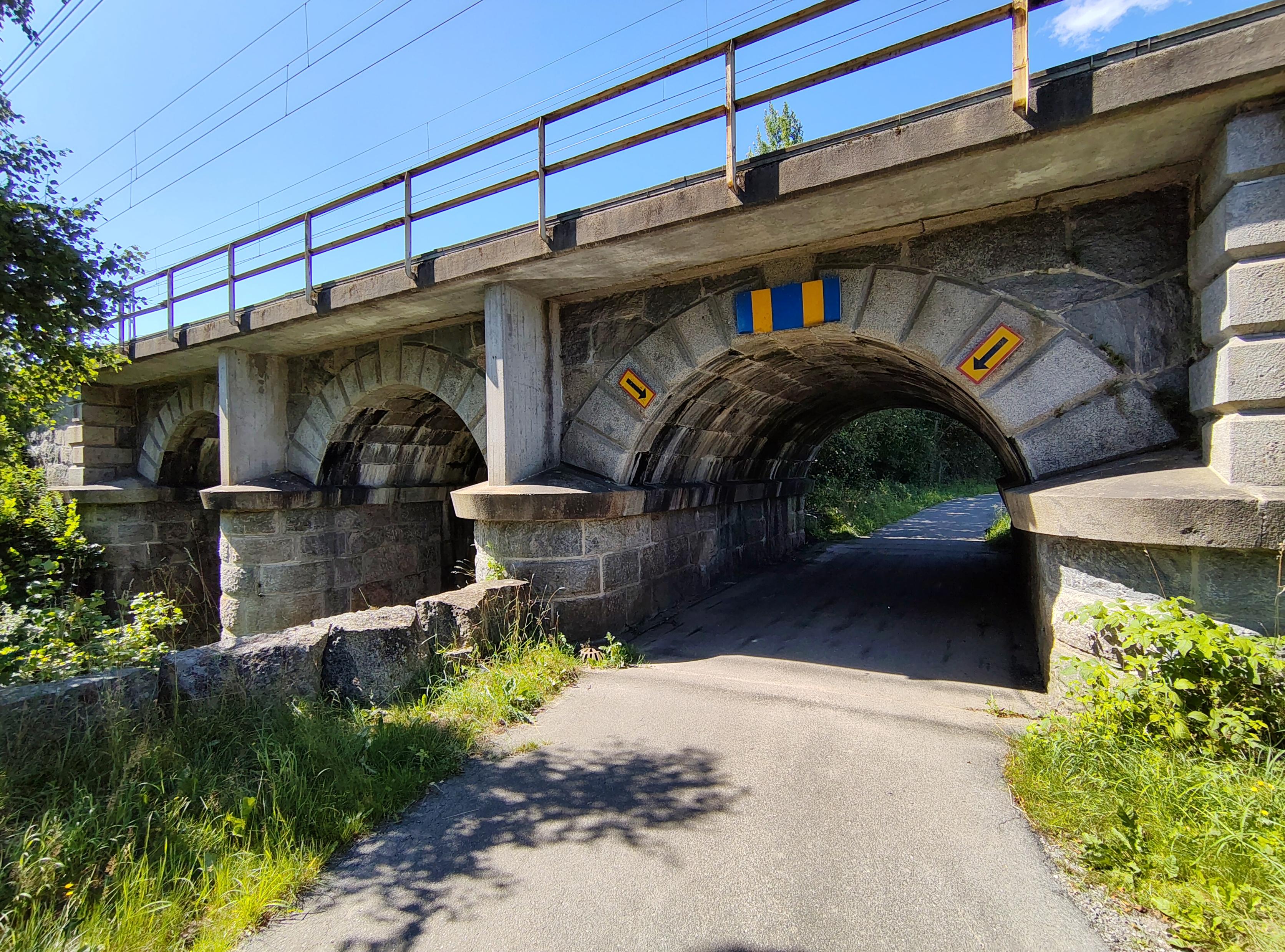 En väg under en murad järnvägsbro.