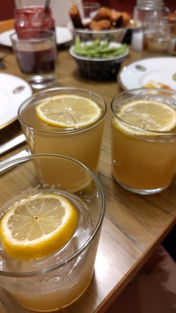 Tre glas med mörkgul drink, is och citron.